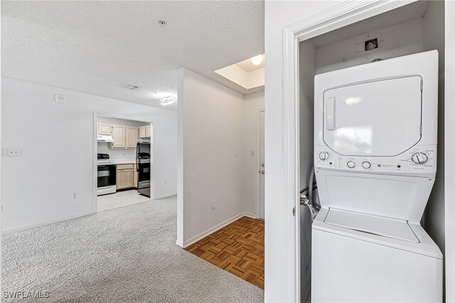 washroom with stacked washer and clothes dryer, light colored carpet, a textured ceiling, laundry area, and baseboards