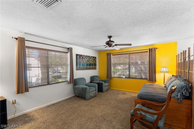 sitting room with ceiling fan, carpet, and a textured ceiling