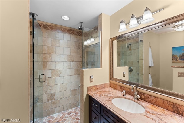 bathroom with a shower with shower door and vanity