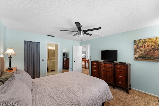 carpeted bedroom featuring ceiling fan, a textured ceiling, and ensuite bathroom