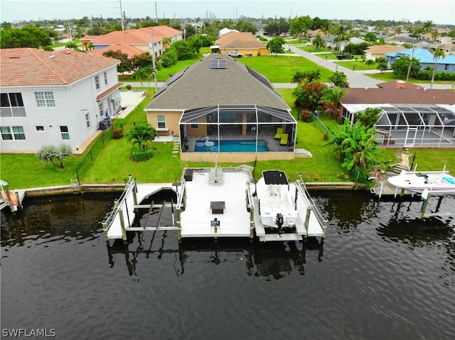 view of dock featuring a lanai, a water view, and a yard