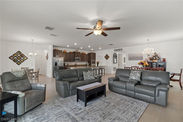 living room with light tile patterned flooring and ceiling fan with notable chandelier