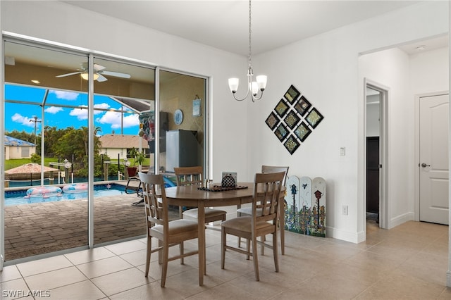 tiled dining area featuring ceiling fan with notable chandelier