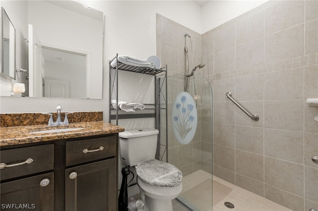 bathroom with tiled shower, toilet, and vanity