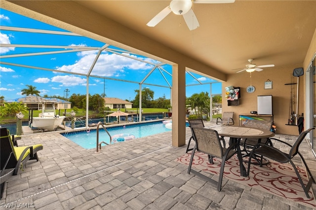 view of swimming pool featuring a patio area, ceiling fan, and glass enclosure