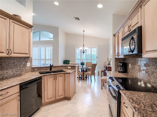 kitchen featuring light tile patterned floors, black appliances, stone counters, and sink