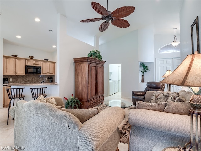 tiled living room featuring ceiling fan and high vaulted ceiling