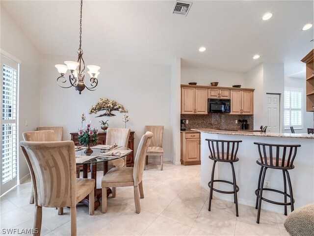 dining space with a notable chandelier, light tile patterned floors, and plenty of natural light