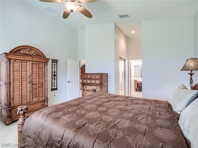 carpeted bedroom with connected bathroom, ceiling fan, and a towering ceiling