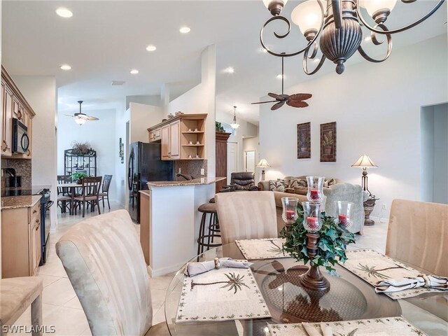 tiled dining area featuring ceiling fan with notable chandelier