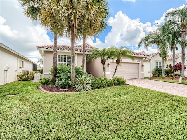 mediterranean / spanish-style house with a garage, cooling unit, and a front yard