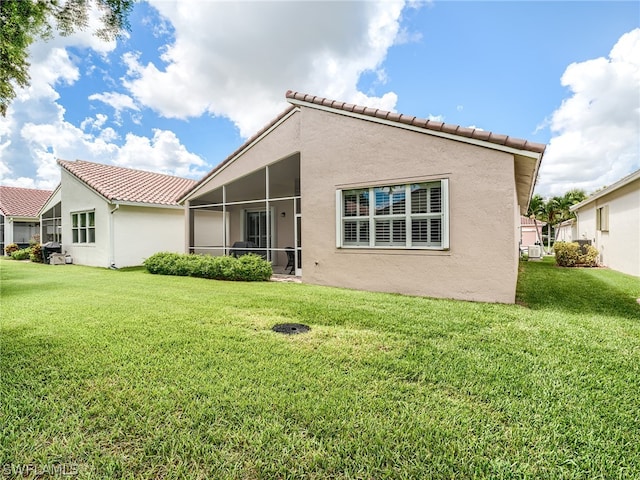 back of house featuring a sunroom and a yard