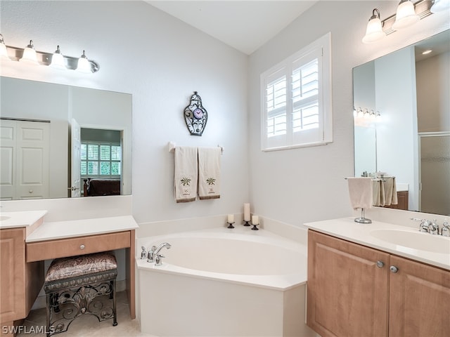 bathroom with a tub, vanity, and a healthy amount of sunlight