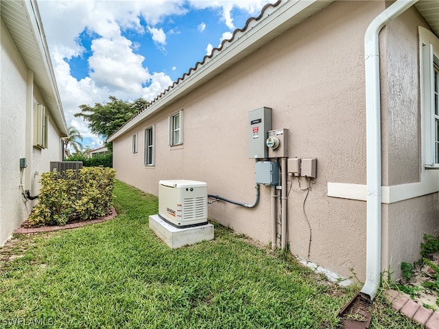 view of side of property featuring central air condition unit and a lawn