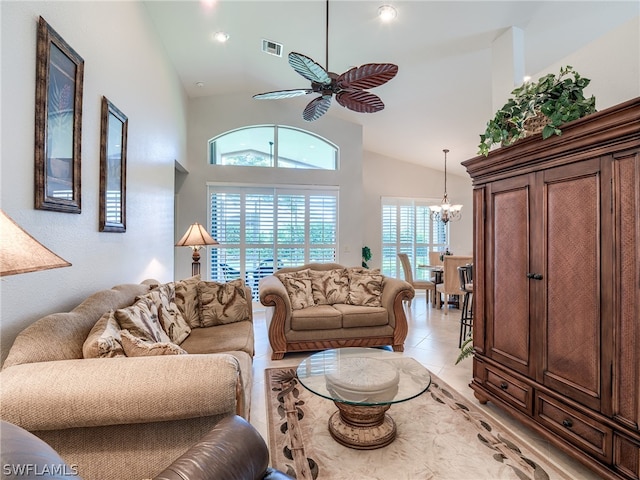 tiled living room featuring ceiling fan with notable chandelier and high vaulted ceiling