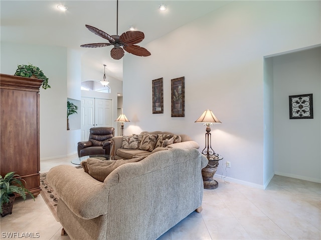 tiled living room with ceiling fan and high vaulted ceiling