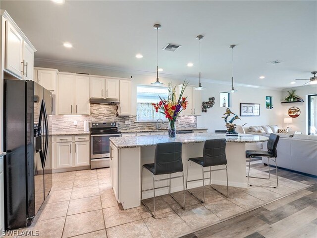 kitchen with stainless steel electric range, black fridge, white cabinetry, and tasteful backsplash