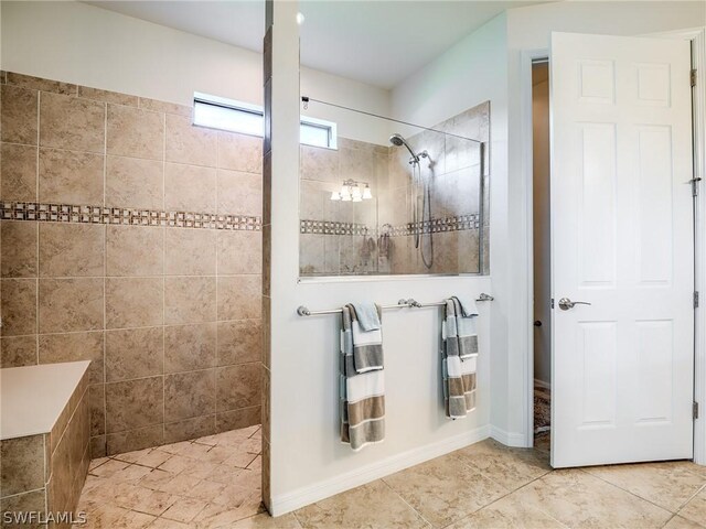 bathroom with tile patterned flooring and a tile shower