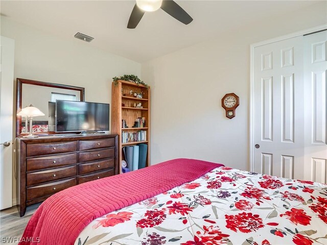 bedroom featuring light hardwood / wood-style flooring, a closet, and ceiling fan