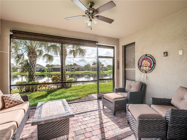 sunroom / solarium with a water view and ceiling fan