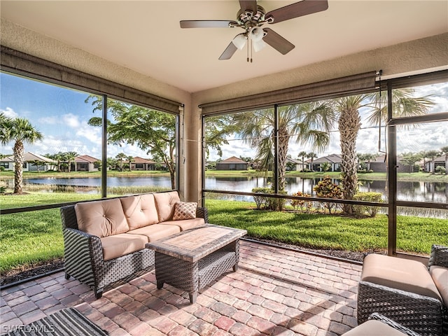 sunroom featuring a water view and ceiling fan