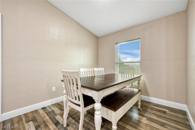 dining area featuring dark hardwood / wood-style flooring and vaulted ceiling