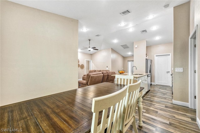 dining area with ceiling fan, sink, dark hardwood / wood-style flooring, and vaulted ceiling