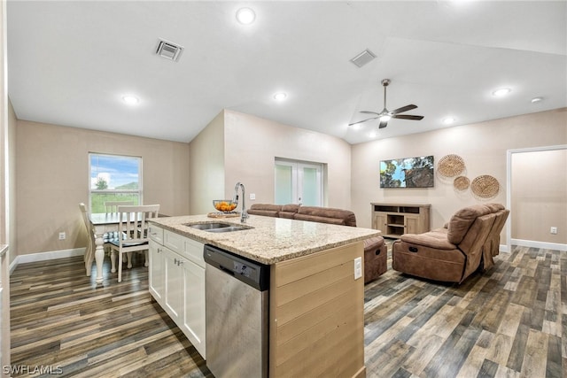 kitchen with lofted ceiling, dishwasher, light stone counters, a kitchen island with sink, and sink