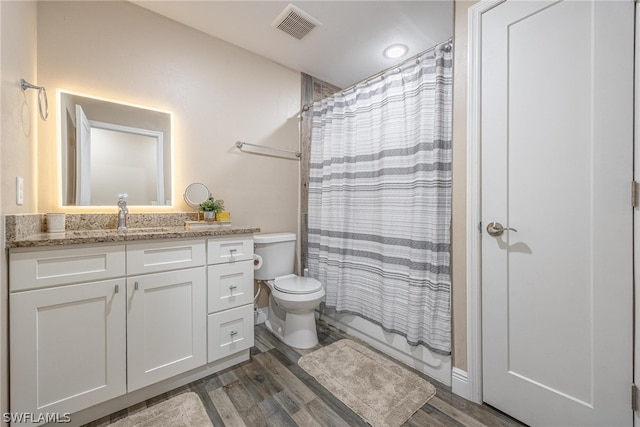 bathroom featuring wood-type flooring, toilet, and vanity