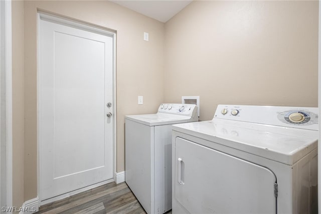 washroom featuring washing machine and clothes dryer and light wood-type flooring