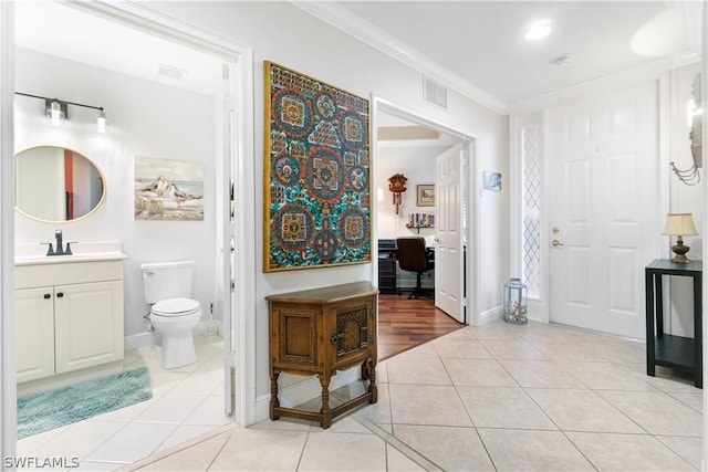 bathroom with tile patterned flooring, vanity, ornamental molding, and toilet