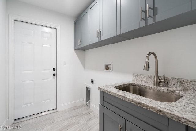 clothes washing area with cabinets, washer hookup, hookup for an electric dryer, and sink