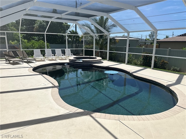 view of pool with glass enclosure, an in ground hot tub, and a patio area