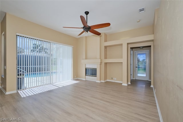 unfurnished living room featuring ceiling fan and light wood-type flooring