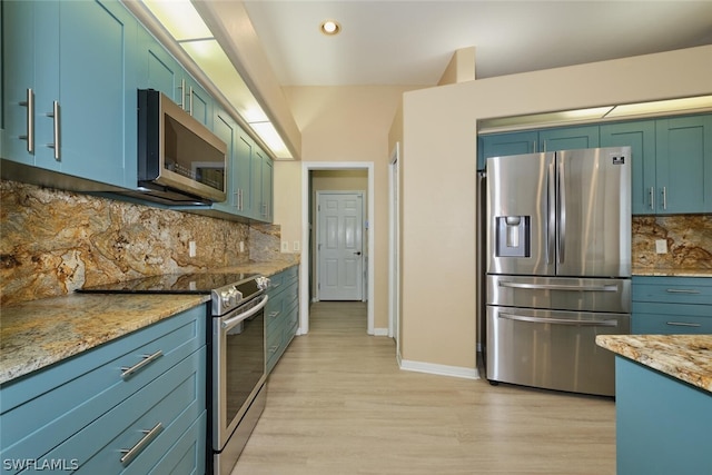 kitchen featuring light stone counters, decorative backsplash, stainless steel appliances, and light hardwood / wood-style flooring