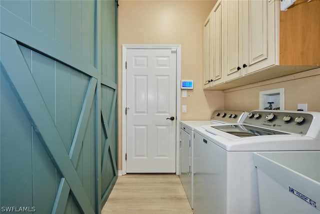 laundry area featuring cabinets, light hardwood / wood-style flooring, and washer and dryer