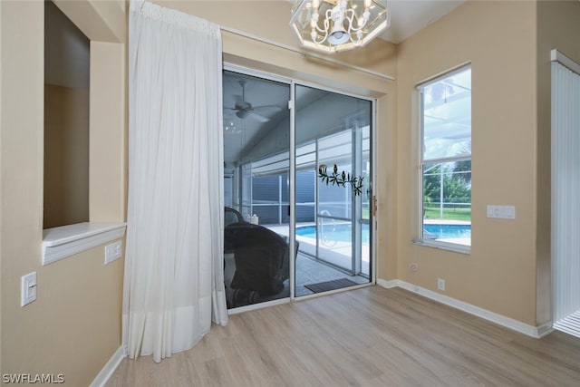 doorway with hardwood / wood-style floors and a chandelier