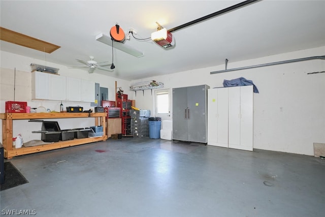 garage with a garage door opener, electric panel, and a workshop area