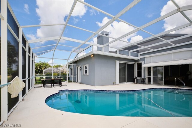 view of swimming pool with a patio and glass enclosure