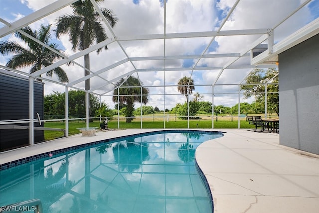 view of swimming pool featuring a lanai, a yard, and a patio area