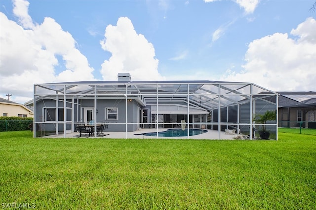 rear view of house featuring a patio, a lanai, and a lawn