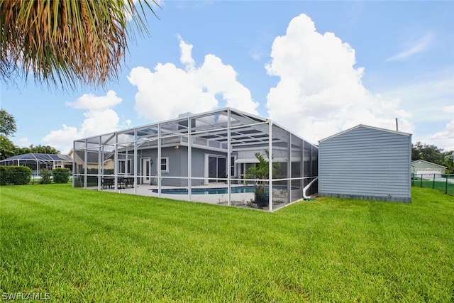 back of house featuring a yard, a lanai, a fenced in pool, and a patio area