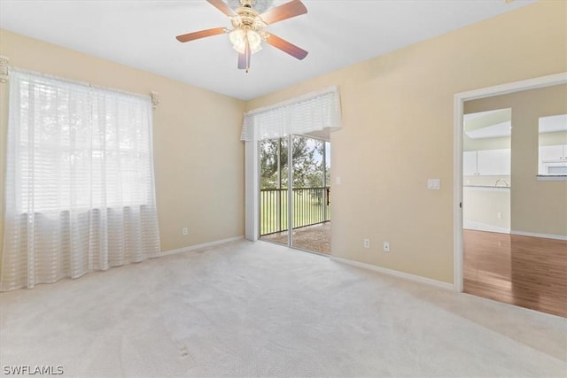 unfurnished room with ceiling fan, light carpet, and plenty of natural light