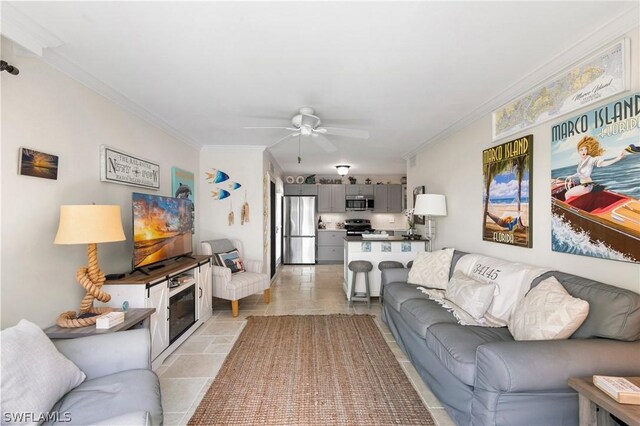 living room featuring crown molding, light tile patterned floors, and ceiling fan