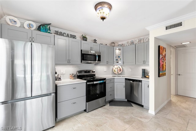 kitchen with decorative backsplash, appliances with stainless steel finishes, gray cabinetry, and light tile patterned floors