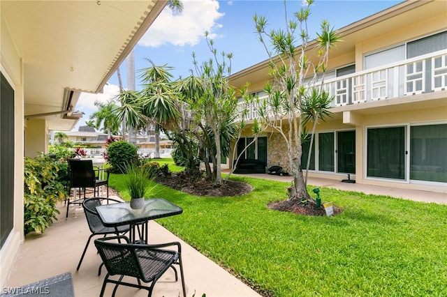 view of property's community with a yard and a patio