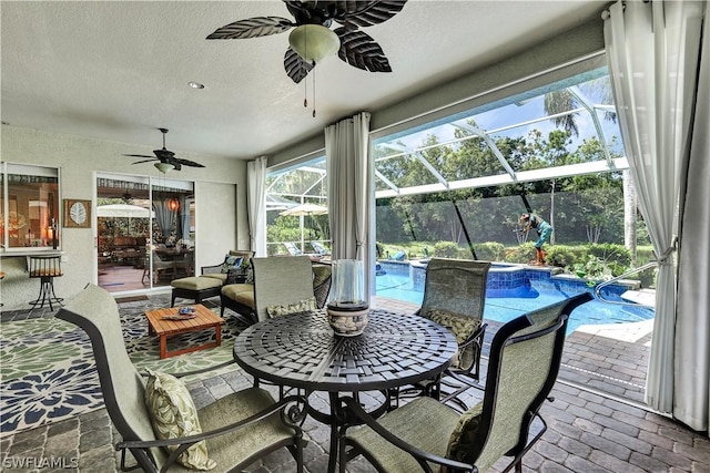 sunroom / solarium featuring ceiling fan