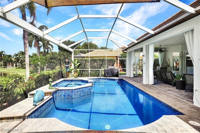 view of swimming pool with an in ground hot tub, ceiling fan, a patio, and glass enclosure