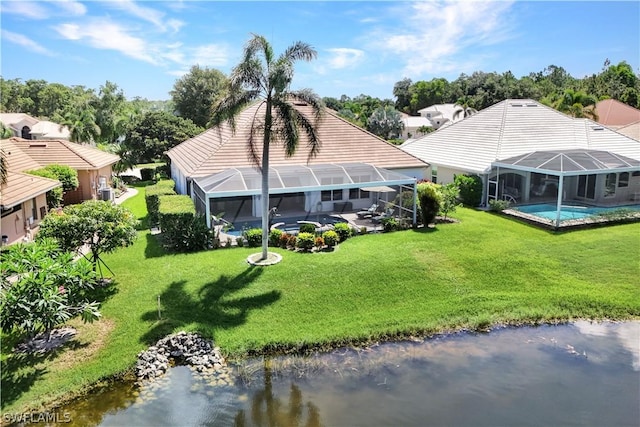 back of property featuring a water view, a yard, and a lanai