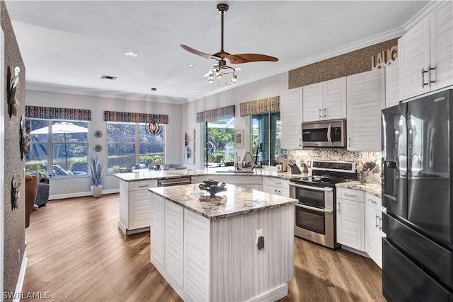 kitchen with white cabinetry, decorative light fixtures, a center island, kitchen peninsula, and stainless steel appliances